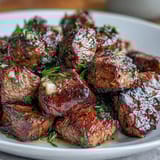 One-pan garlic herb steak bites with fresh parsley, cooked to golden perfection in a cast iron skillet.