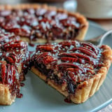Rich chocolate bourbon pecan tart with flaky crust, perfect for dessert.