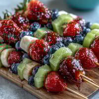 Festive Fourth of July fruit skewers with strawberries, bananas, and blueberries arranged in patriotic colors for summer celebrations.