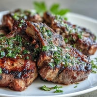 Tender lamb chops grilled to perfection, topped with a vibrant mint gremolata for a fresh, zesty finish.