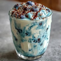 Creamy probiotic kefir blueberry flaxseed smoothie topped with fresh berries.